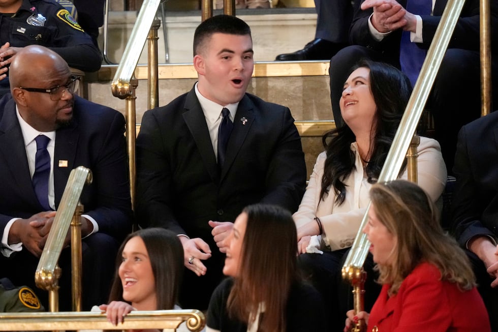 Jason Hartley, center, reacts as President Donald Trump addresses a joint session of Congress...